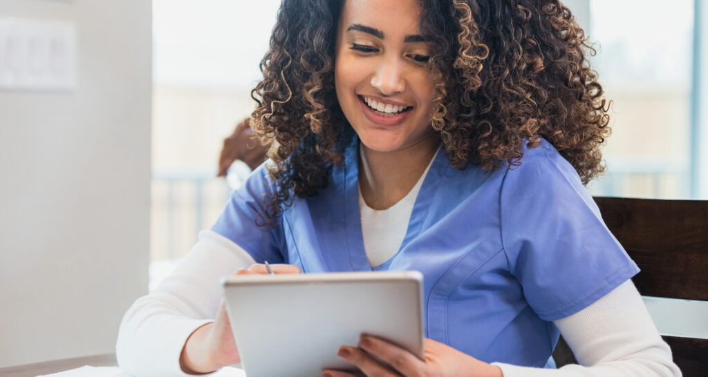 Home healthcare nurse reviews patient information on digital tablet