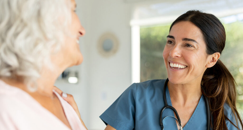 female healthcare professional laughs with elderly patient