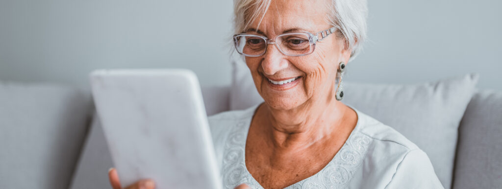 elderly woman video chats on tablet in spanish