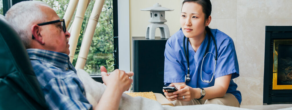 healthcare professional talks to elderly patient