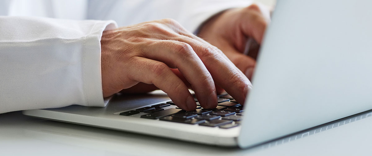 medical professional hand typing on computer keyboard